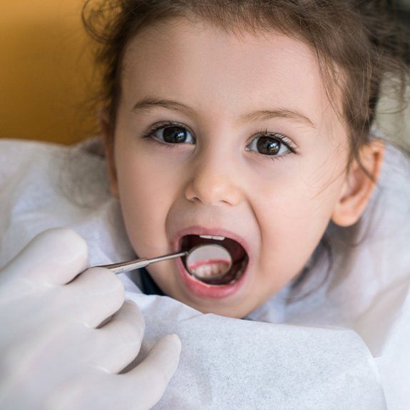 Young girl receiving dental exam after tooth-colored filling placement