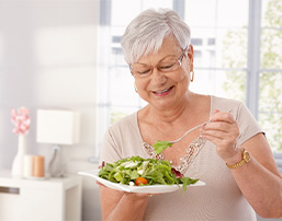 Senior woman with glasses eating a salad