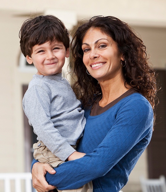 Mother holding happy child after children's dentistry appointment