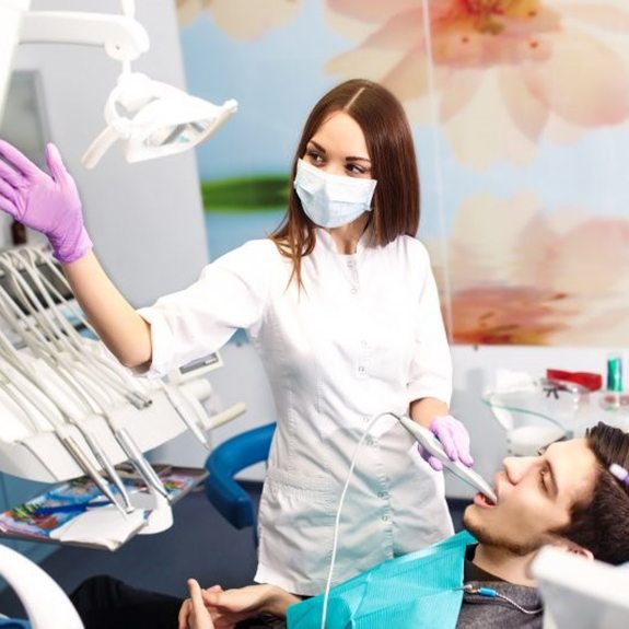 A woman using an intraoral scanner on a patient.