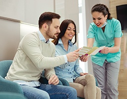 a couple speaking with their dental assistant about pricing