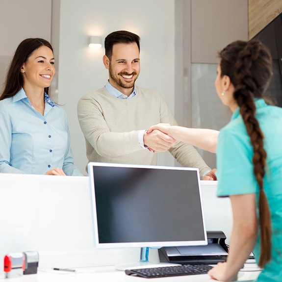 dental team member shaking a patient’s hand 