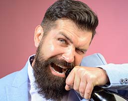 Man opening a wine bottle with his teeth