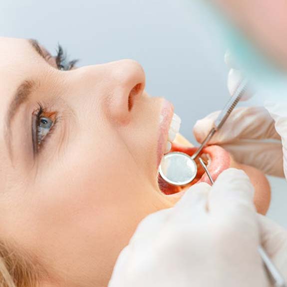 Woman in need of emergency dentistry holding jaw