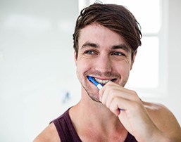 Man practicing dental implant care in Royse City by brushing