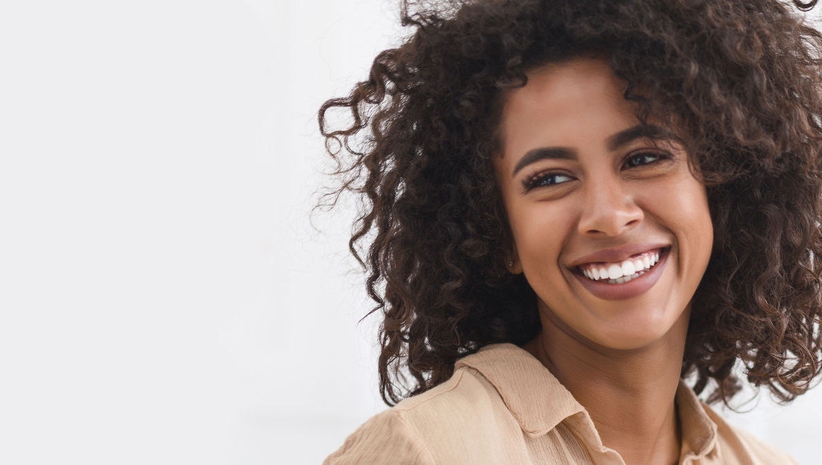 Smiling woman with curly hair looking off to the side