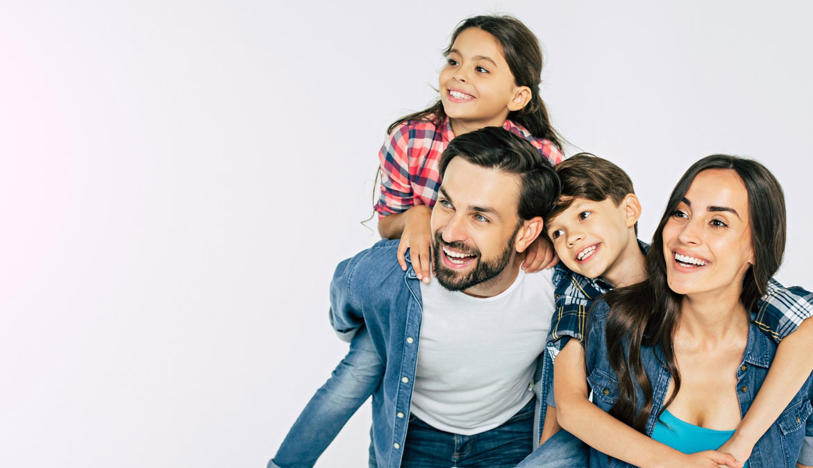 Mother father and two kids smiling while looking off to the side