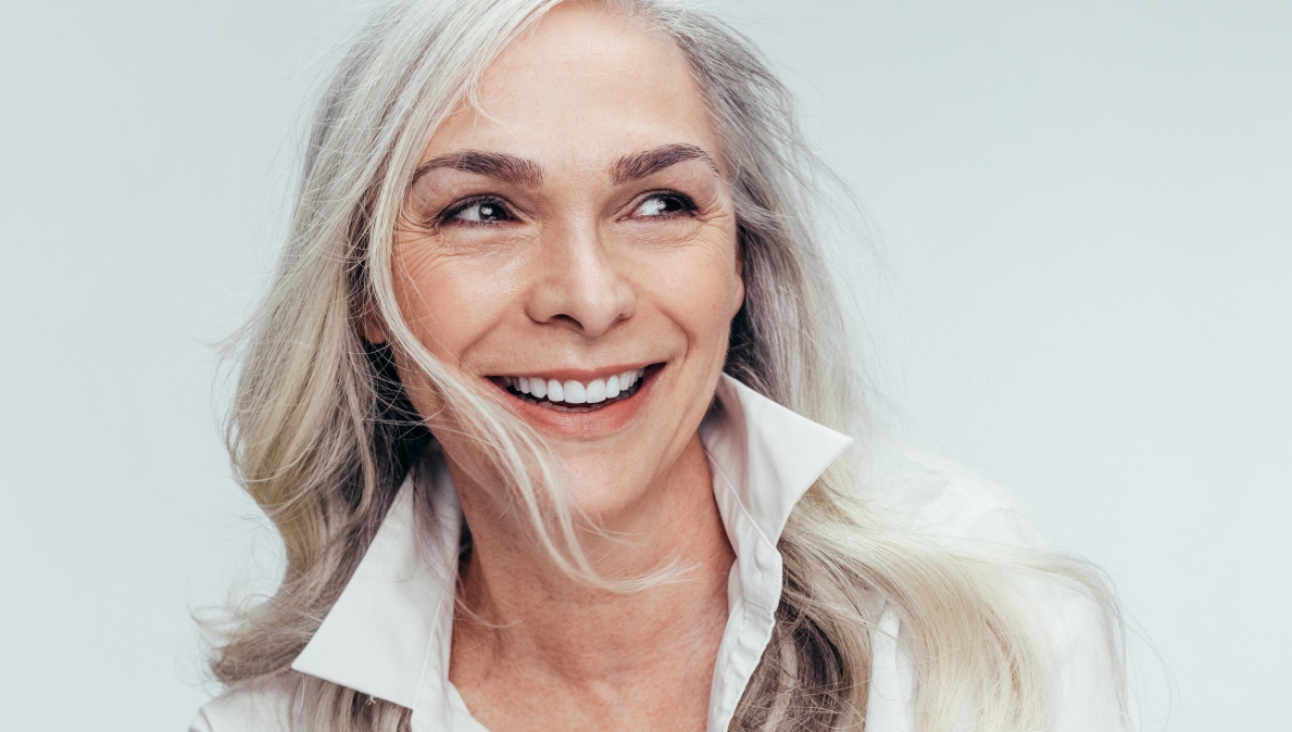 Older woman with long gray hair smiling