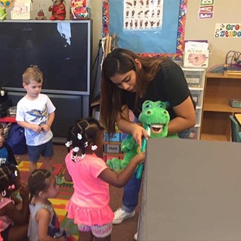 Royse City dental team member teaching child how to brush teeth