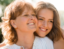 Mother and daughter smiling outdoors