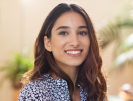 Woman in flowery blouse smiling outdoors