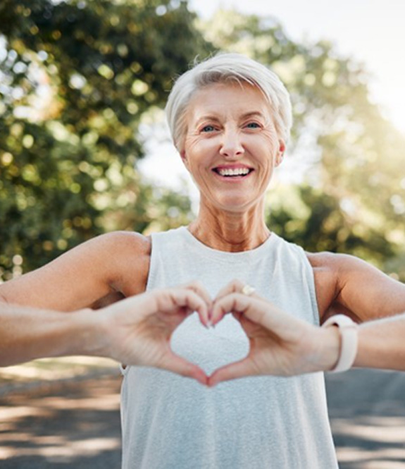 Lady smiles while making shape of heart