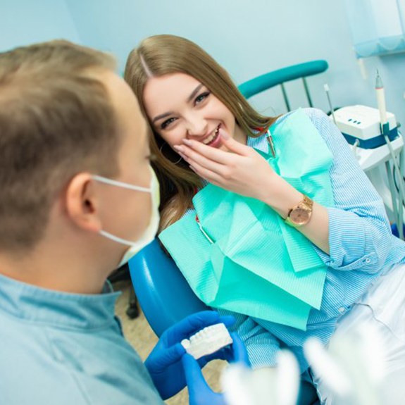 young woman smiling at her dentist 