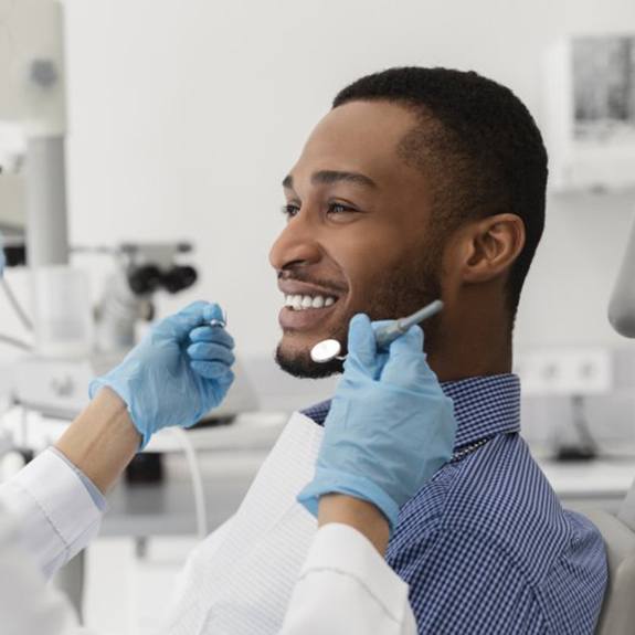 young man smiling at his dentist 