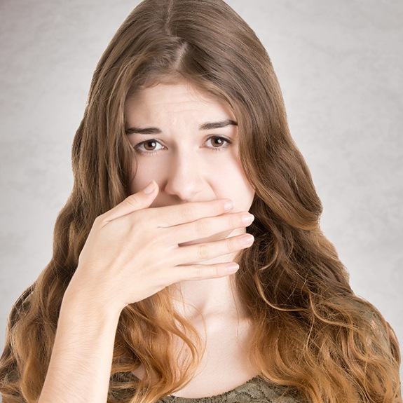 A woman covering her mouth.