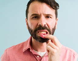 Man pulling down lip to show signs of gum disease in Royse City, TX