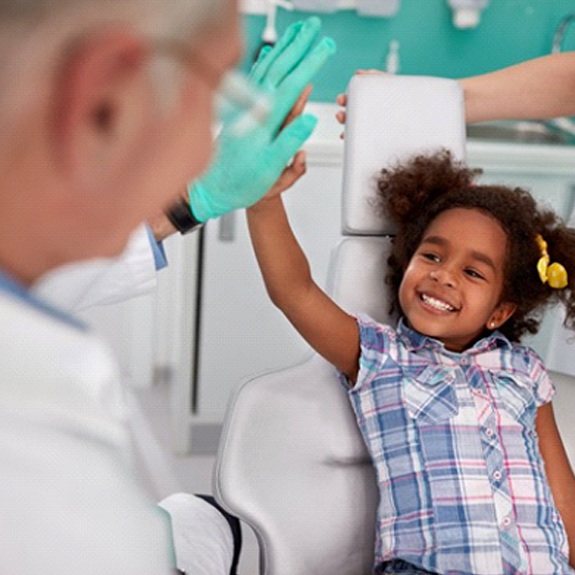 little girl giving her dentist a high-five 