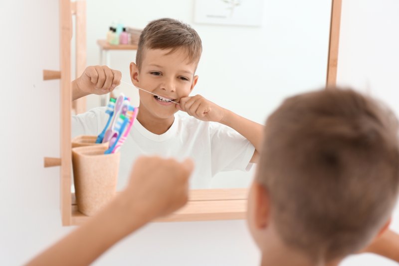 Boy using dental floss