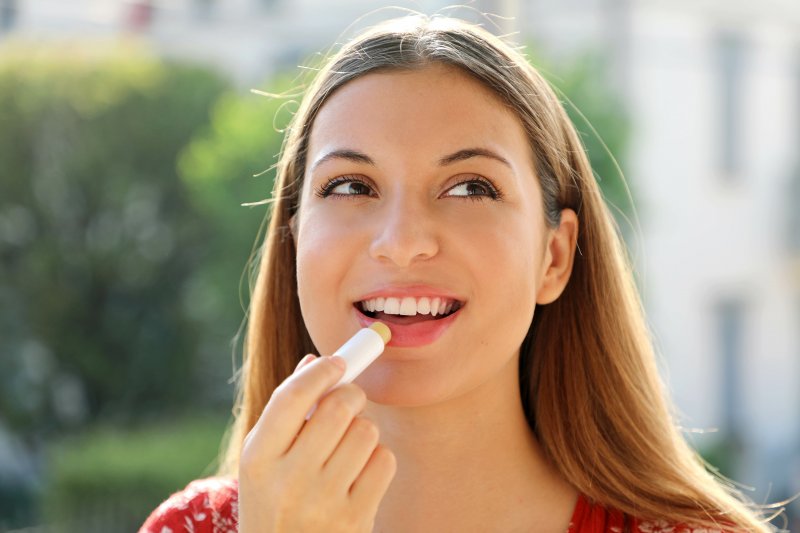 girl applying lip sunscreen outside during summer