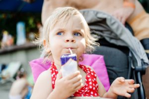 Child looks suspicious while drinking fruit juice