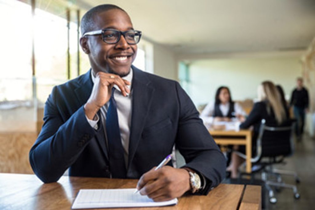 Man smiling during a meeting at his job.