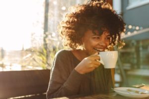 a woman with veneers drinking coffee