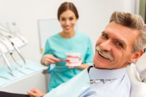 a dentist showing her patient good denture habits