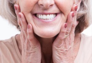 a woman smiling while wearing her dentures