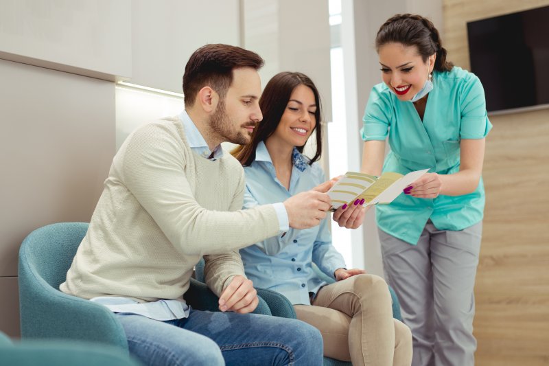 A couple talking to their dentists about cosmetic dentistry and insurance