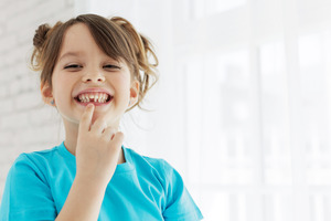 Little girl showing gap left by lost baby tooth